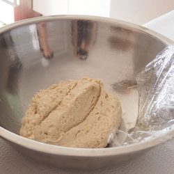 手順6：別のボウルに油を塗り、5を入れる。ラップに油を塗り、かぶせる。暖かい所で約40分、膨らむのを待つ。